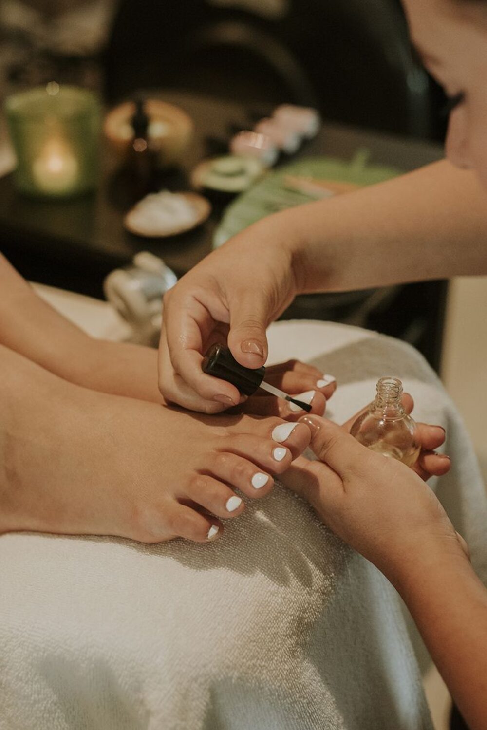 Massage des pieds avec fleurs et bougies